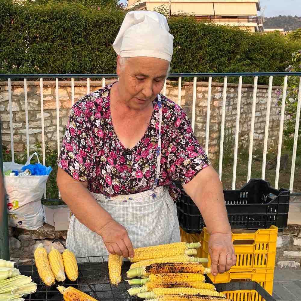 Maisoma ▶︎ konzentrierte Dame beim Maiskolben grillen I GREEKCUISINEmagazine