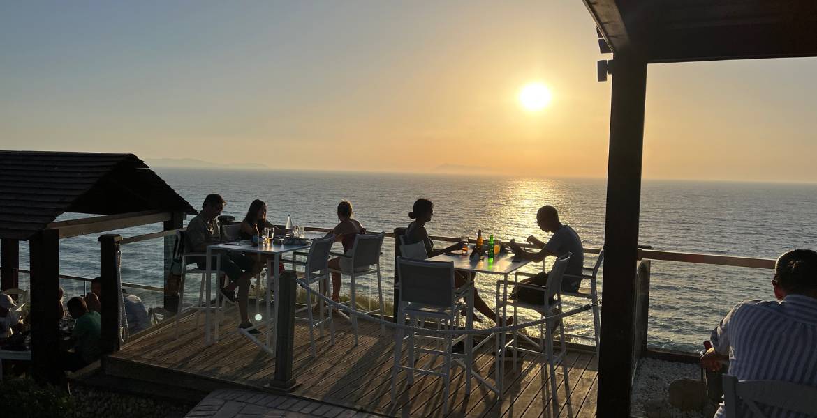 Loggas Sunsetbeach ▶︎ Menschen sitzen an der Bar I GREEKCUISINEmagazine